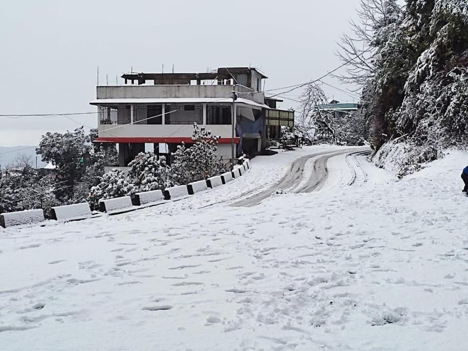 大吉岭RHODODENDRON stay的一条有雪覆盖的道路,后面有一座房子