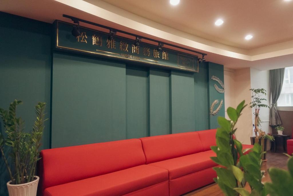 马公松鹤雅致商务旅馆的带有标志的房间的红色沙发