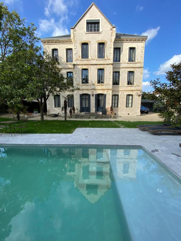卡尔卡松Demeure Saint Louis, Cité 10mn à pieds, PARKING Privé, BORNES 7,2 KW, AC, FULL WIFI的一座大型建筑,前面设有一个游泳池
