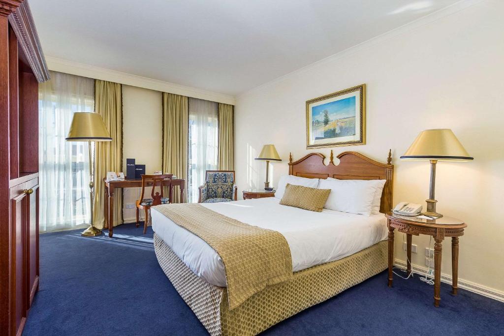 Forest Hill坎特伯雷国际酒店的酒店客房设有一张大床和两盏灯。