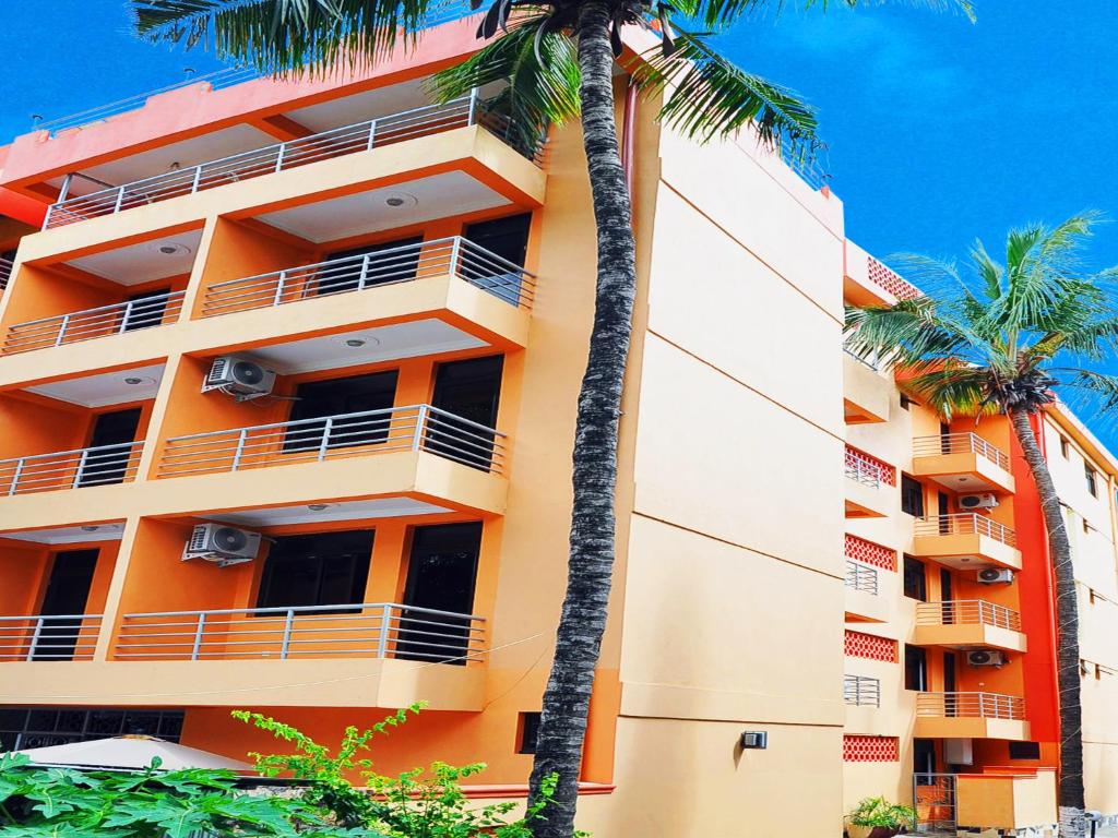 姆特瓦帕蒙娜丽莎酒店的一座种植了棕榈树的橙色建筑