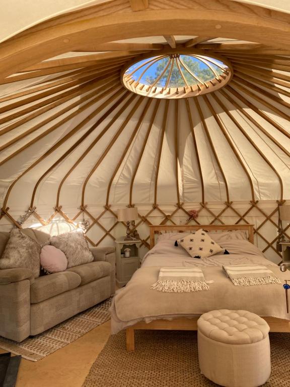 阿克斯明斯特The Yurt @ Osmore的蒙古包内带一张床和窗户的房间