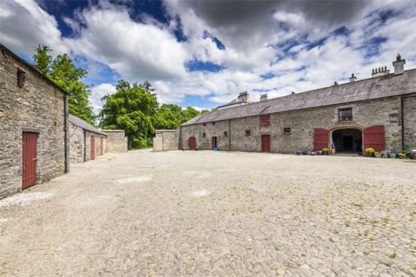 凯尔斯2 Bed Courtyard Apartment at Rockfield House Kells in Meath - Short Term Let的大型石质谷仓,设有大型车道