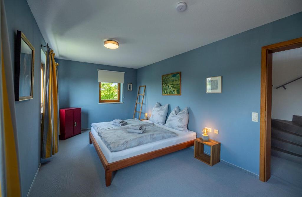 农嫩霍恩Exklusives Josenhaus mit See- und Alpenblick & Gartensauna的一间卧室配有一张带蓝色墙壁的大床