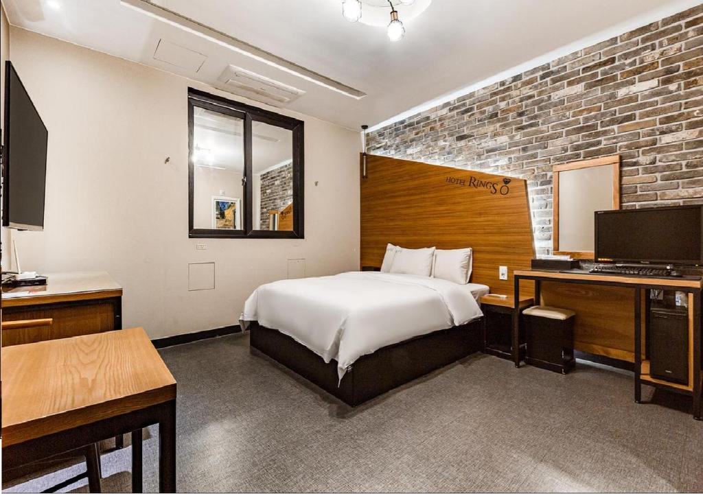 群山市Motel Rings的一间卧室配有一张床和一张带电脑的书桌