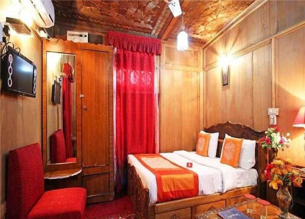 斯利那加Calm Holiday Inn的一间卧室,配有一张床铺和一张火车上的椅子