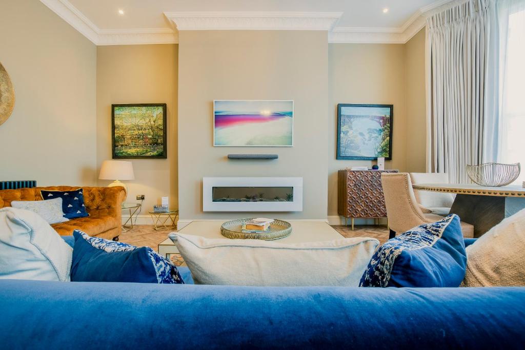 斯卡伯勒Derwent House Apartments的客厅设有蓝色的沙发和壁炉