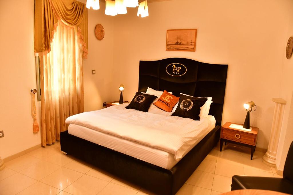 阿卡The German House的一间卧室配有一张带橙色和黑色枕头的大床
