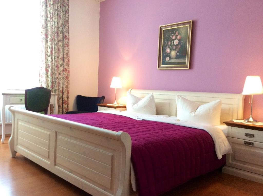 索林根霍尔舍酒店的一间卧室配有一张紫色墙壁的床
