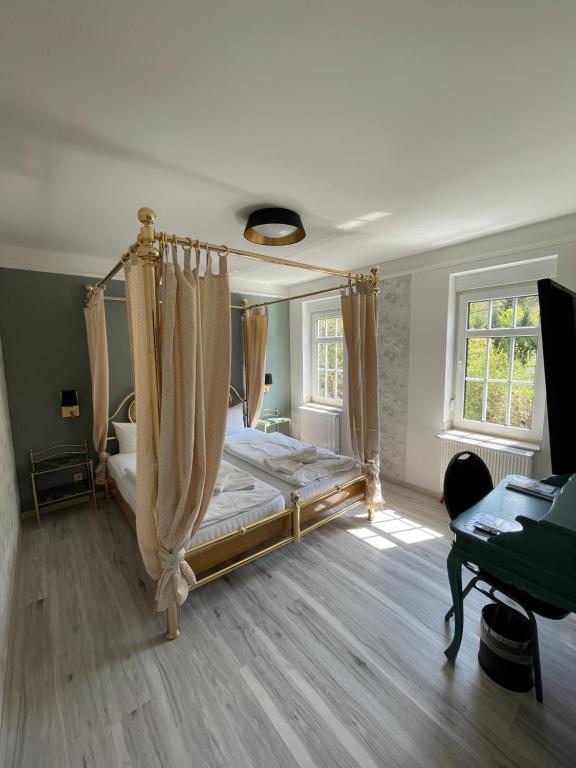 艾森纳赫Haus Hennesburg, garni的一间卧室配有一张天蓬床和一张书桌