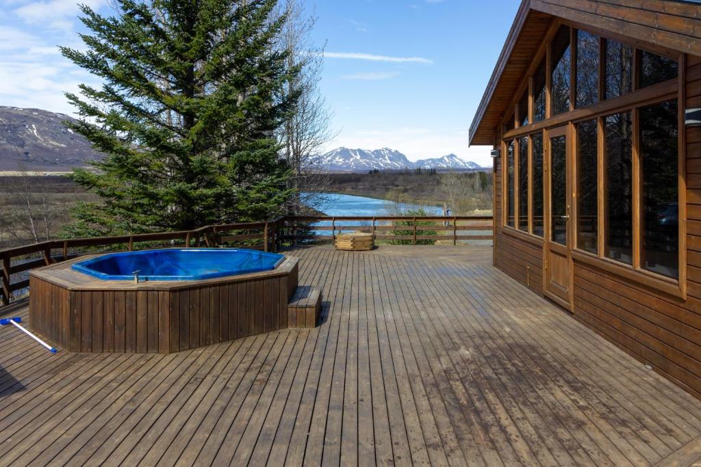 雷克霍特Gorgeous Riverside Lodge in the South of Iceland的大楼旁甲板上的热水浴池