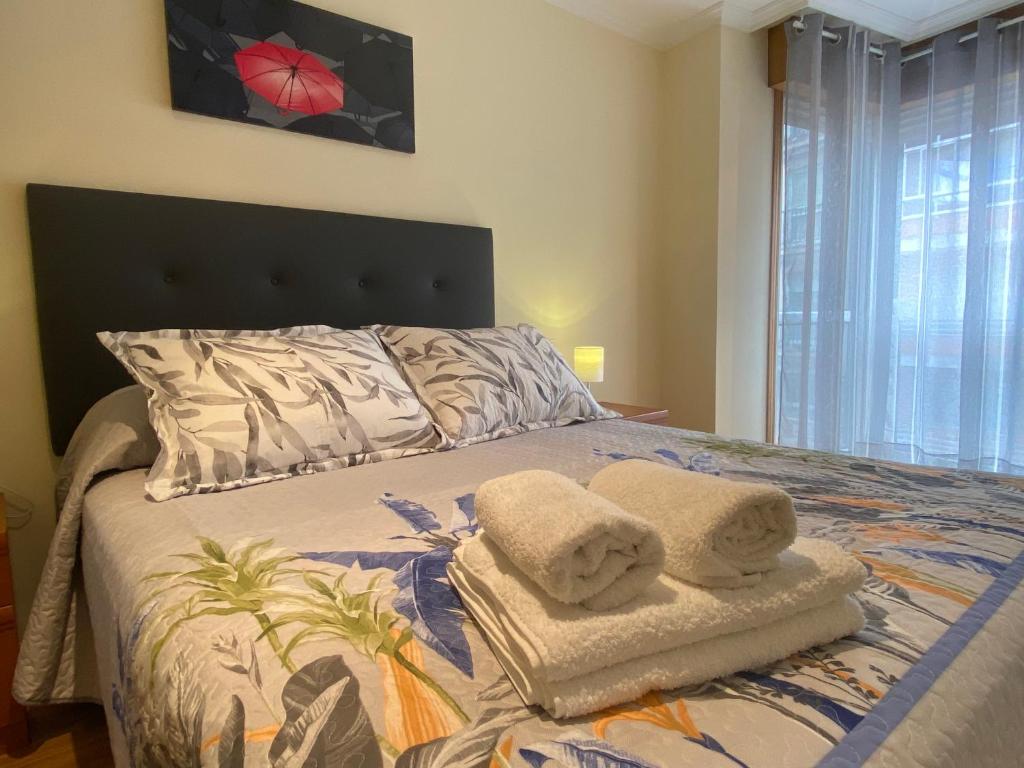 拉林APARTAMENTO FUNCIONAL LALIN-CENTRO的一间卧室配有带毛巾的床