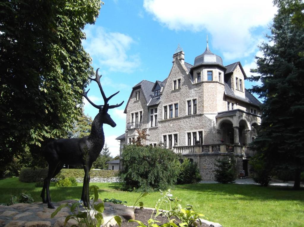 塔勒斯特克兰伯格城堡酒店的一座大厦前的鹿雕像