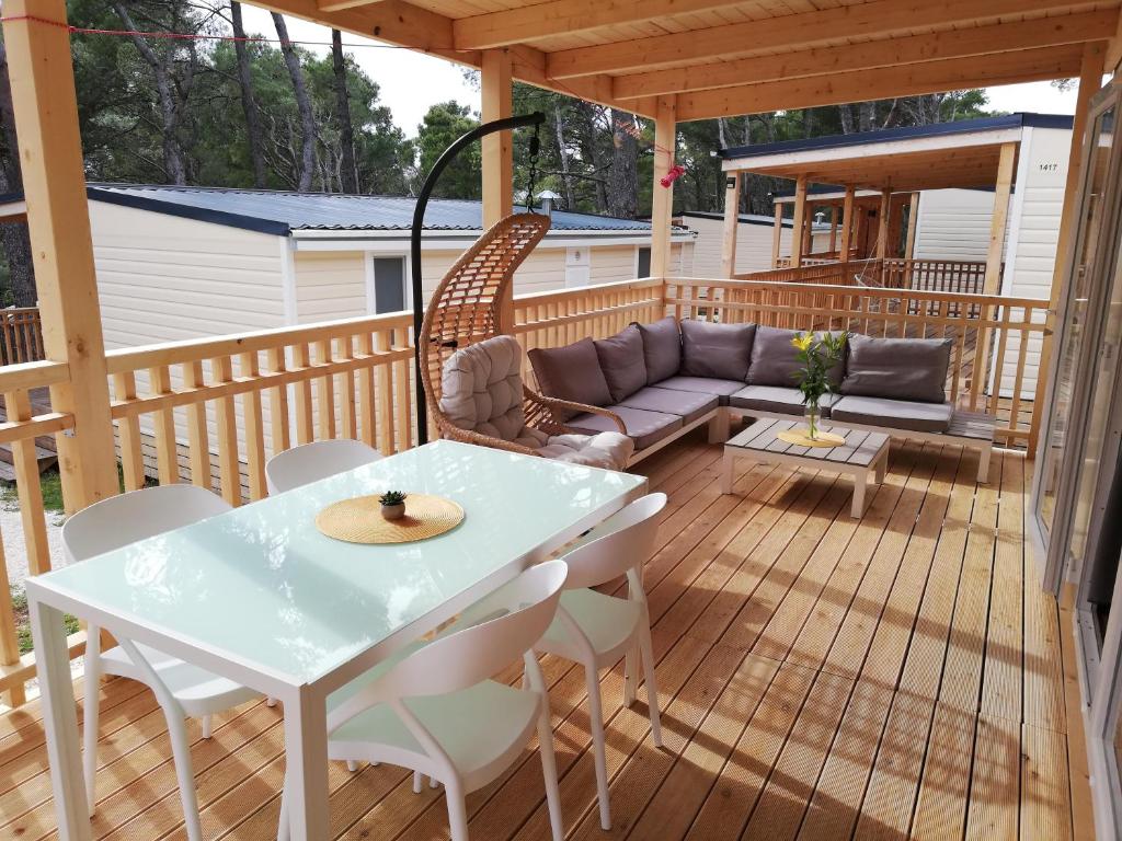 巴什卡沃达RELAX Mobile Home Camp Basko Polje #NEW2022的平台上设有带沙发和桌子的庭院