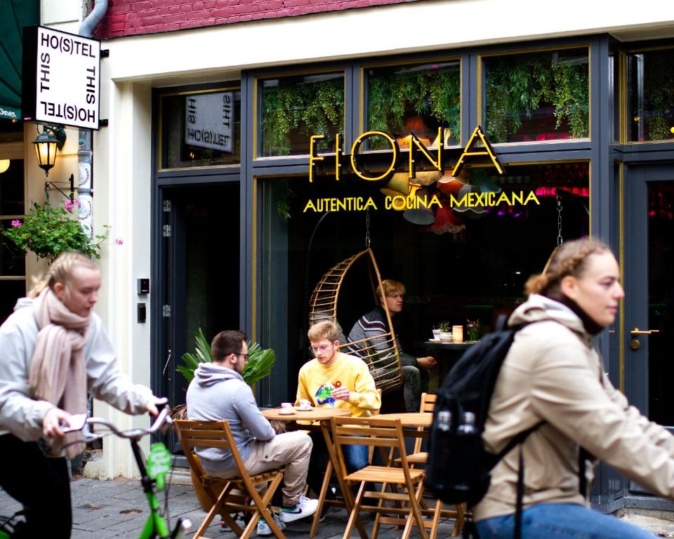 阿姆斯特丹THIS HO(S)TEL的一群人坐在餐厅外的桌子上