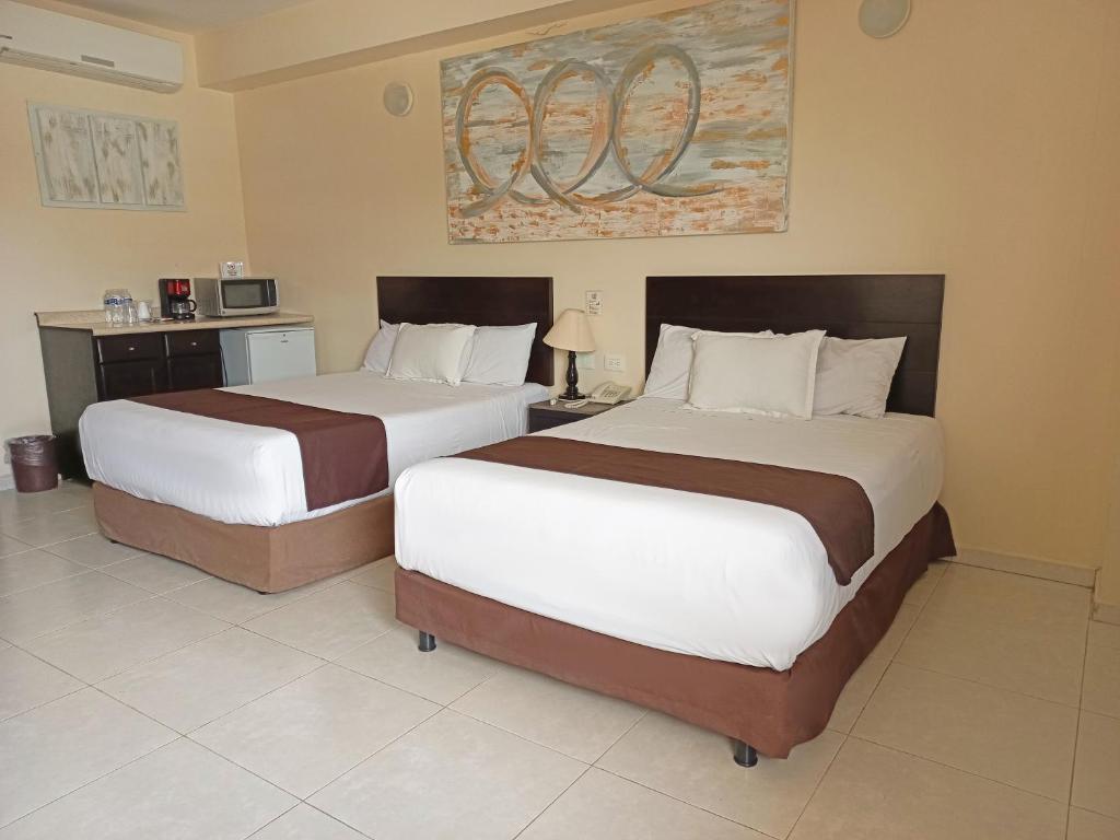 比亚埃尔莫萨HOTEL VILLA MARGARITAS的配有两张床的酒店客房中的两张床