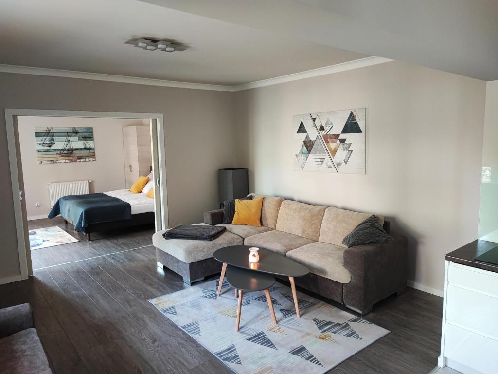 斯维诺乌伊希切Apartament Feniks 12 - 63 m2的客厅配有沙发、桌子和床。