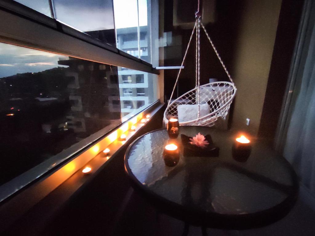 萨拉热窝Sky Way Studio Apartment的一间设有桌子和蜡烛窗户的房间