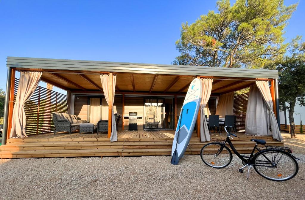 比奥格勒·纳·莫鲁Mobile Home Karlo的一座房子,上面有冲浪板和自行车停放在房子前面