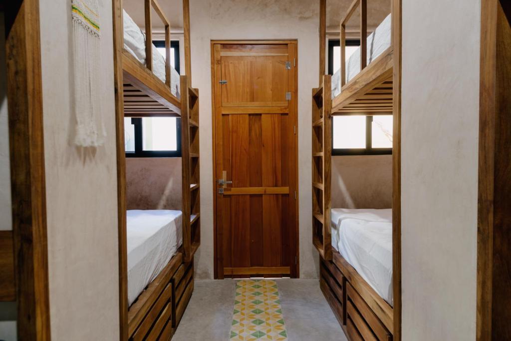 梅里达Hostik Hostal的带两张双层床和一扇门的房间