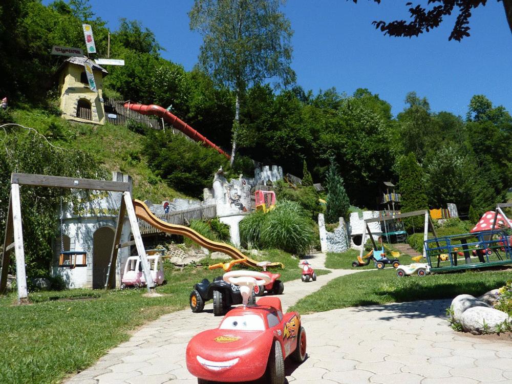 TrebesingSmileys Kinderhotel的一个带玩具车和游乐场的公园