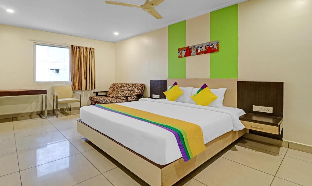 维杰亚瓦达Itsy By Treebo - G Square的一间卧室设有一张大床和色彩缤纷的墙壁