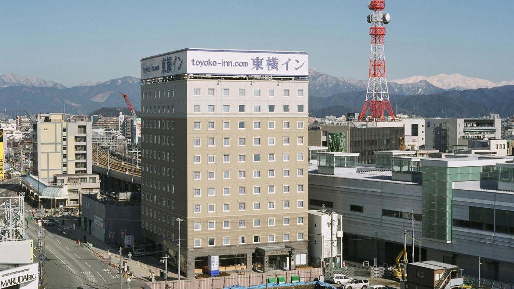 福井Toyoko Inn Fukui Ekimae的一座高大的建筑,上面有标志