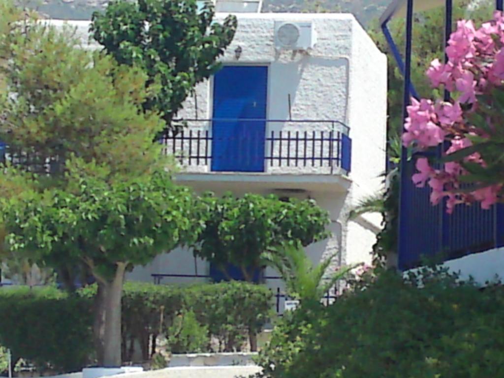 卡利斯托斯Aetos Beach Bungalows的一座带蓝色门和阳台的建筑