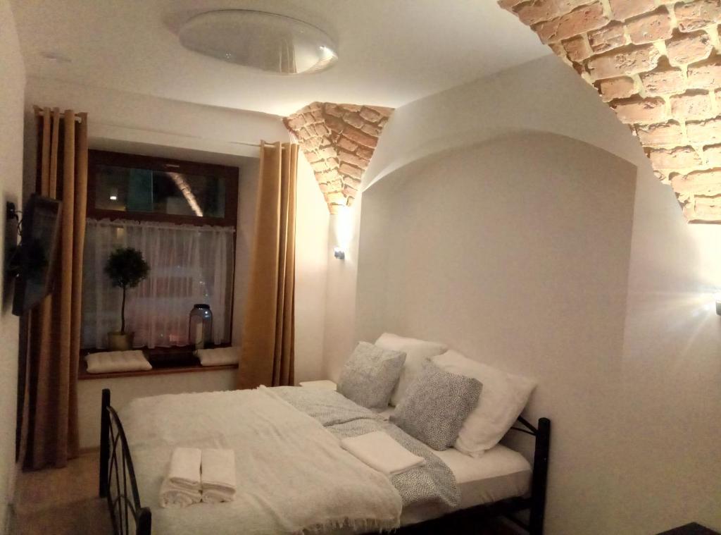 拉德库夫RadkowRynek21的一间卧室配有带白色床单和枕头的床。