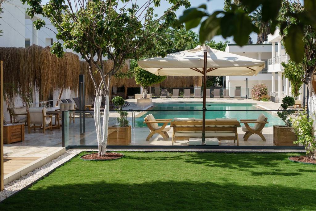 博德鲁姆Costa Maya Bodrum的一个带遮阳伞、长凳和桌子的游泳池