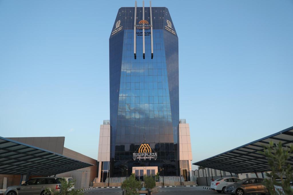 塞卡凯Tulip Plaza Hotel的一座高大的玻璃建筑,上面有标志