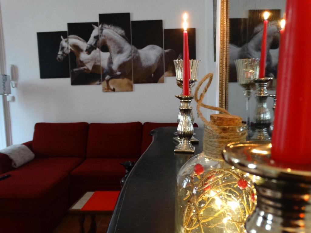 索米尔Studio Séquoia au pied du Château的客厅配有一张桌子和两个红色蜡烛