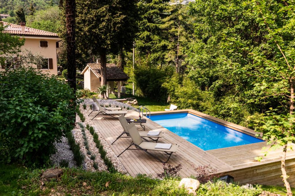 Castion VeroneseRelais Villa Alma的房屋旁的游泳池设有甲板和椅子