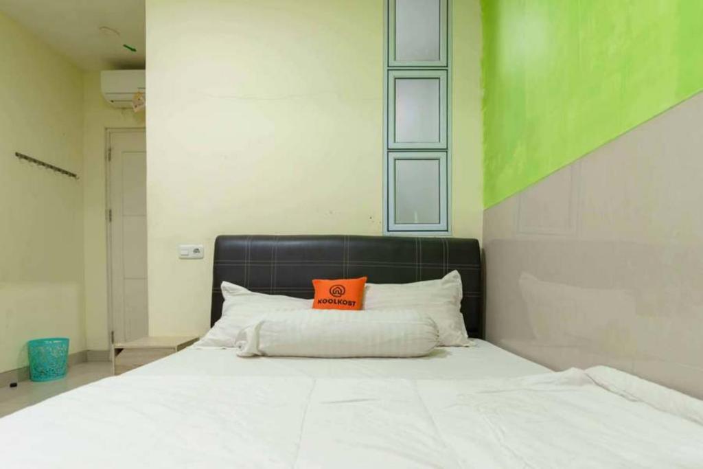 名古屋KoolKost near Nagoya Hill Batam (Minimum Stay 30 Nights)的床上有一个橙色枕头