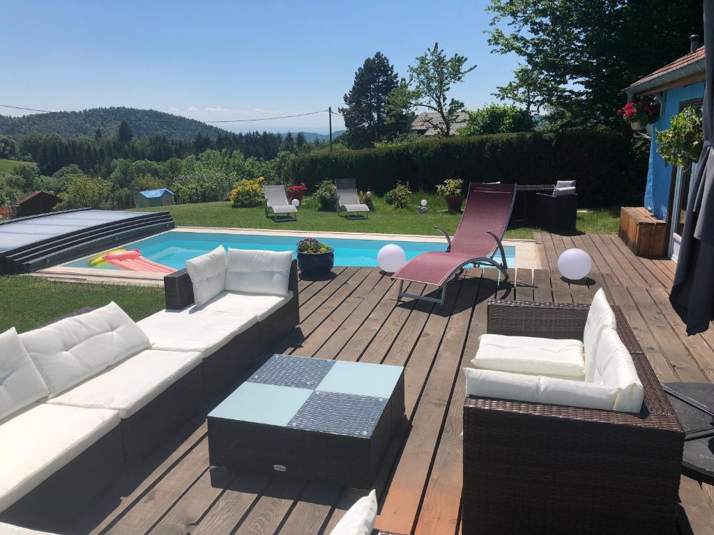 AltenbachLa maison bleue的一个带沙发和椅子的庭院和一个游泳池