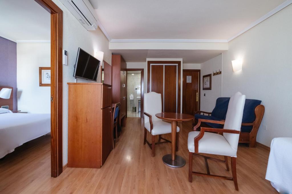 阿尔么丽亚Torreluz Apartamentos的酒店客房带一张床、一张桌子和椅子