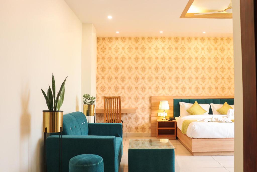 德拉敦Hotel Royal Palm Dehradun的一间卧室配有一张床和两张蓝色椅子