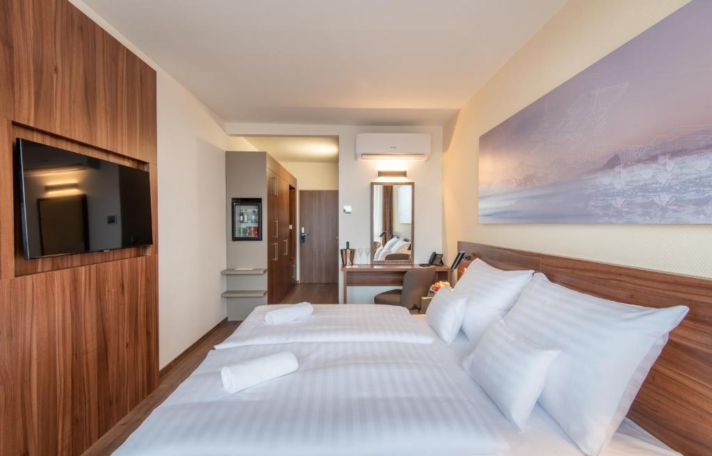 赫维兹Hunguest Hotel Panoráma的酒店客房设有两张床和电视。