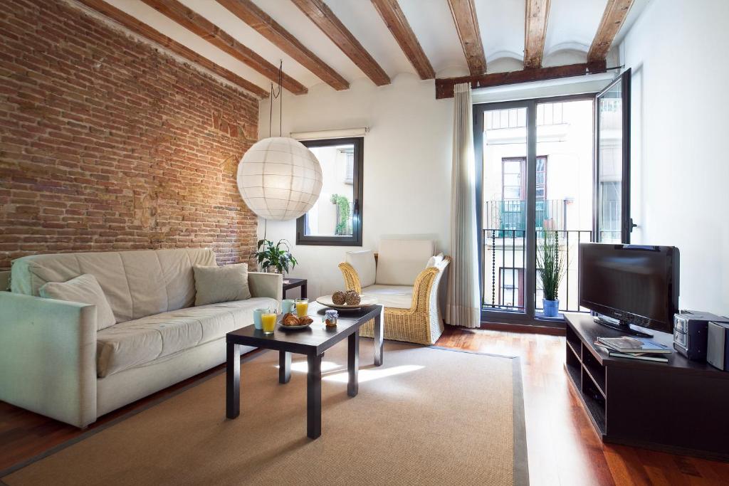 巴塞罗那埃斯帕特里亚巴塞罗那市内公寓的客厅配有白色沙发和砖墙