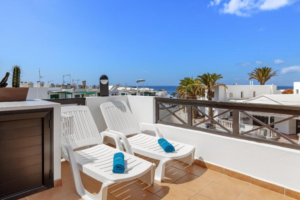 蒂亚斯Holiday in Lanzarote!的阳台上的两把白色椅子