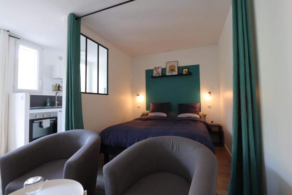 格雷乌莱班Studio tout confort - Climatisation, parking, wifi的一间卧室配有一张床和两把椅子