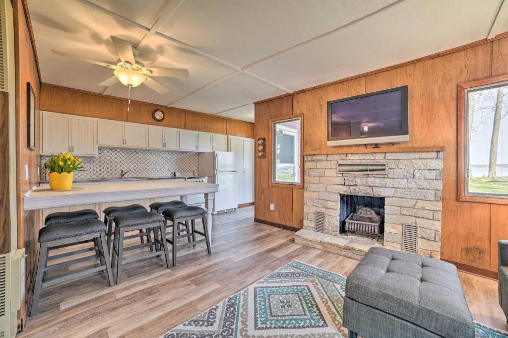 Cozy Petoskey Area Retreat on Burt Lake Access!的厨房设有带壁炉的客厅。