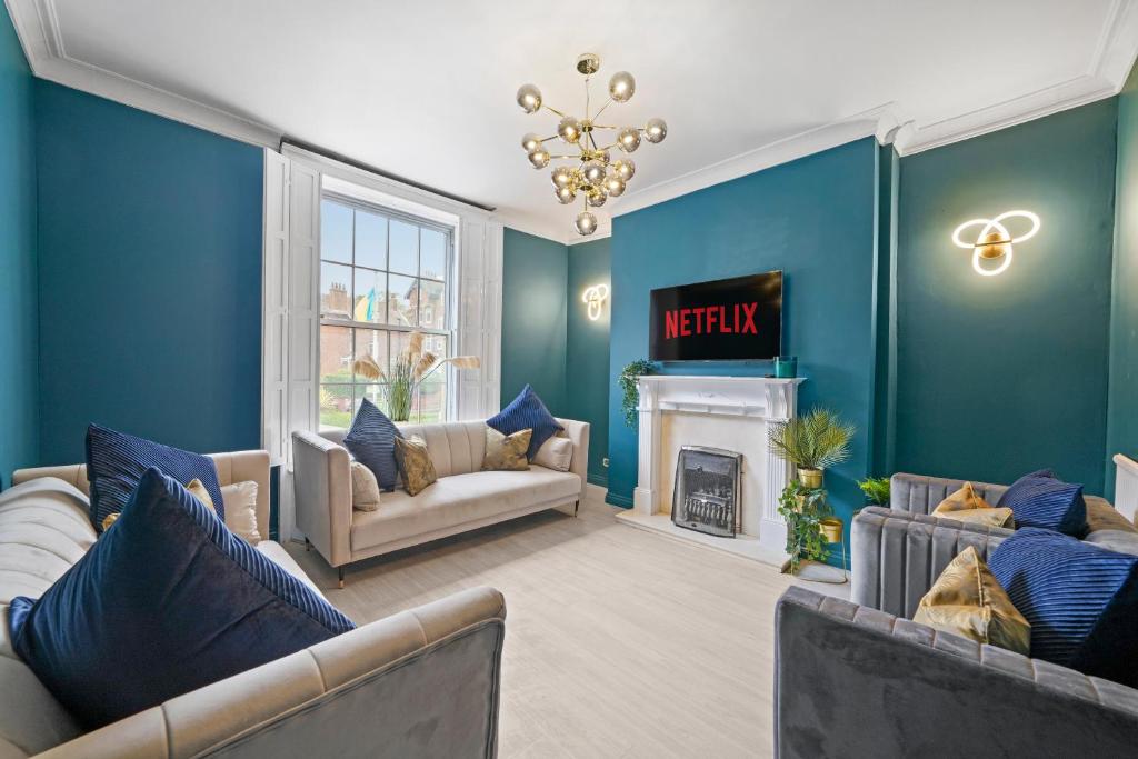 惠特比The Most Central and Lux Whitby House - Hot-Tub的蓝色的客厅设有两张沙发和一个壁炉