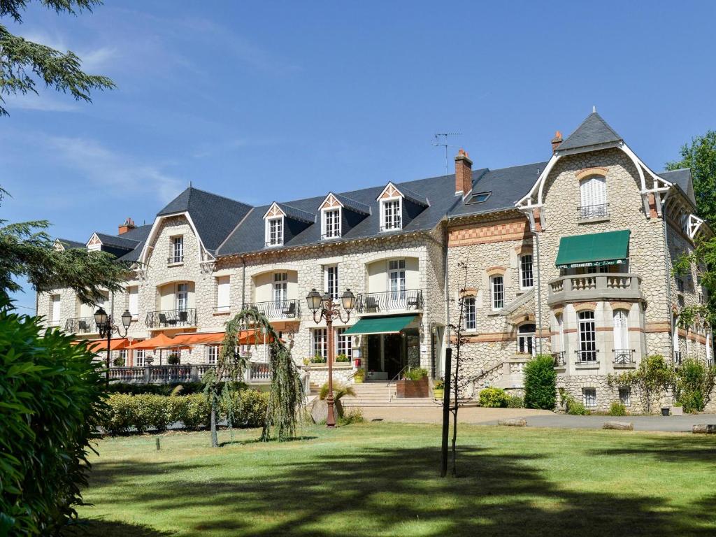 萨勒布里Logis Hôtel Restaurant Le Parc的一座大型石头建筑,前面有草坪