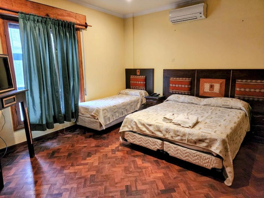 萨尔塔Tradición de Salta的一间卧室配有两张床和电视。