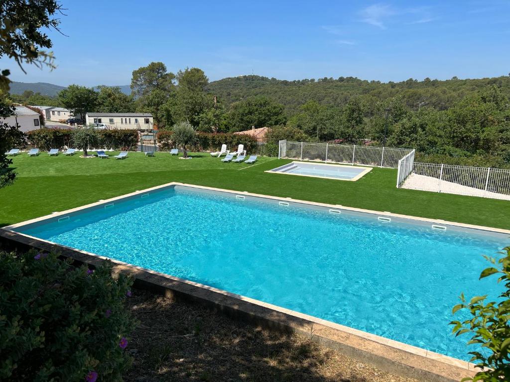 RocbaronJoli Mobil-Home de Vacances, Ideal pour les familles的庭院里的大型游泳池,配有椅子