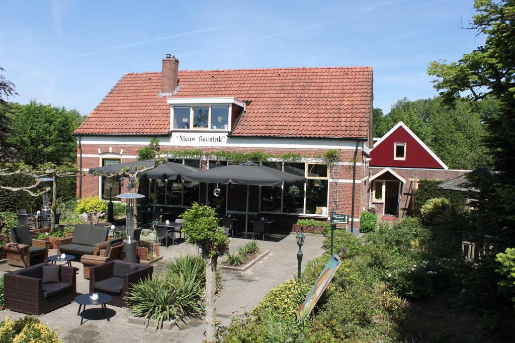 温特斯韦克Boutique Hotel Nieuw Beusink的一座建筑,设有餐厅,配有椅子和遮阳伞