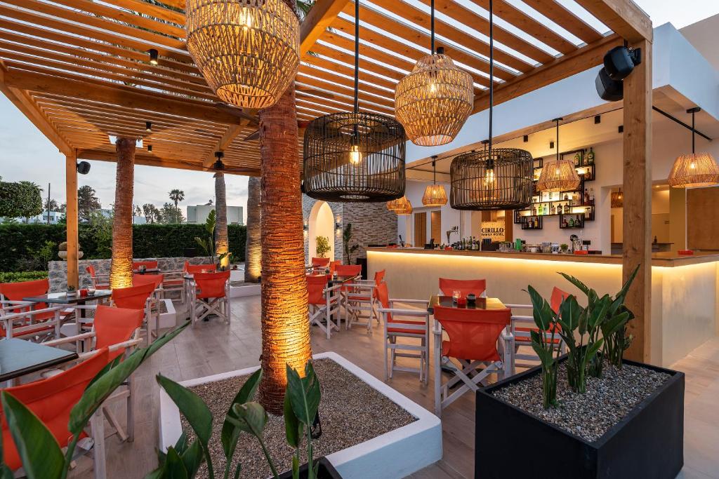 马斯蒂查里Cirillo Family Hotel-Christinas Studios的餐厅设有桌椅和吊灯。
