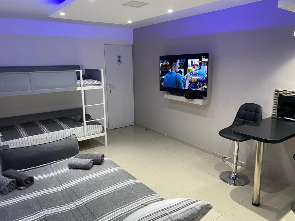 埃拉特Perfect House的卧室配有一张床,墙上配有电视。