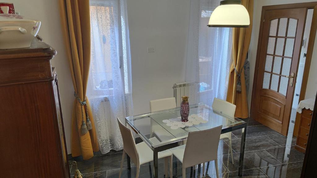 罗马La Badia del Cavaliere 1的玻璃餐桌、白色椅子和灯